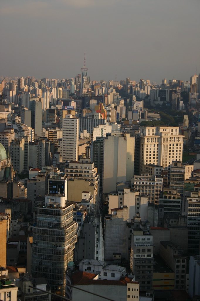 Skyline denso do centro de São Paulo visto do alto no fim da tarde, prédios até o horizonte