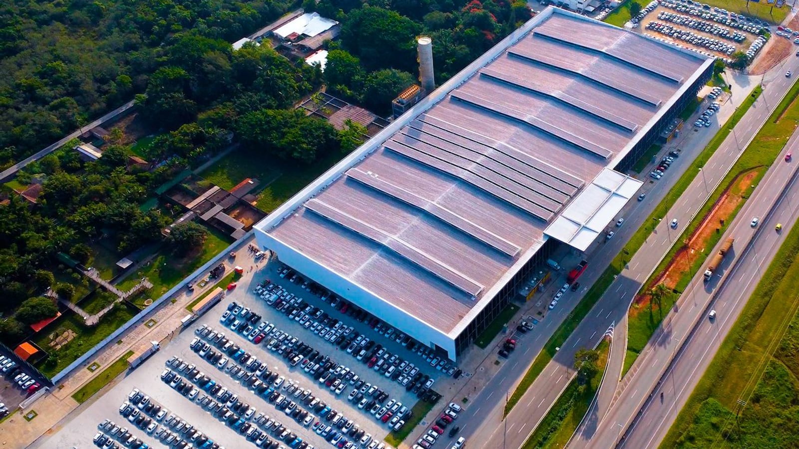 Vista aérea do pavilhão do Expocentro Balneário Camboriú, com o estacionamento cheio e a rodovia ao lado